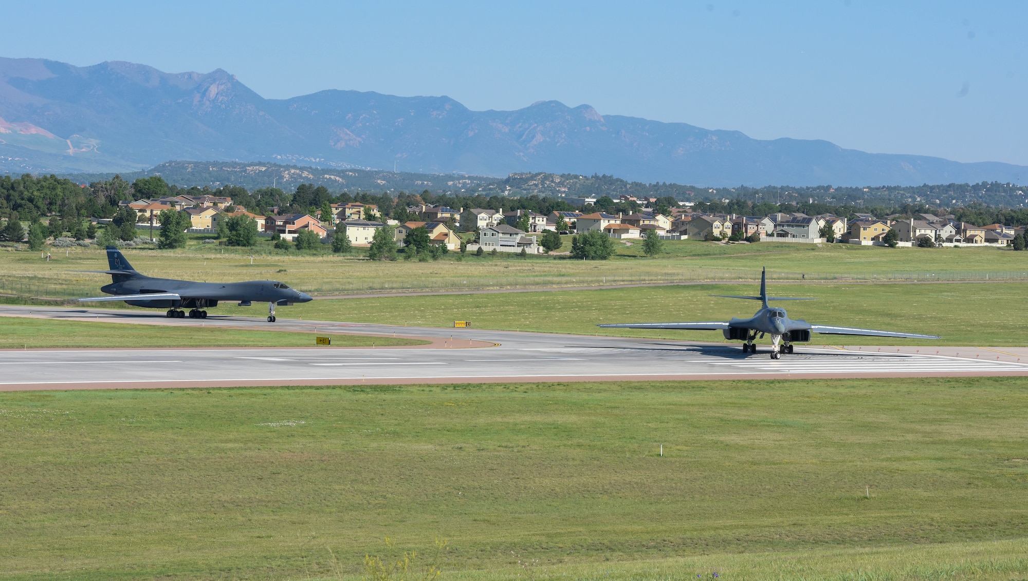 Two B-1B Lancer aircraft taxi down the runway
