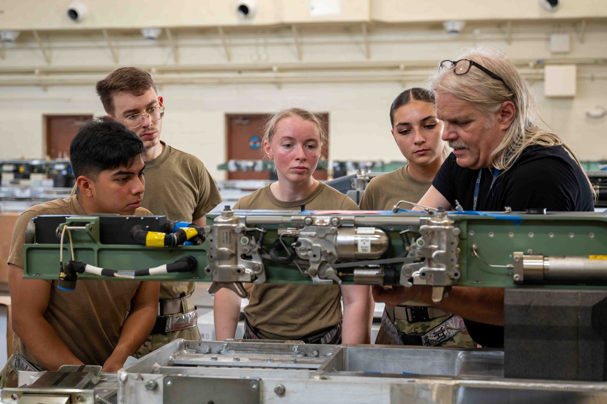 service members look at machine to get on the job training