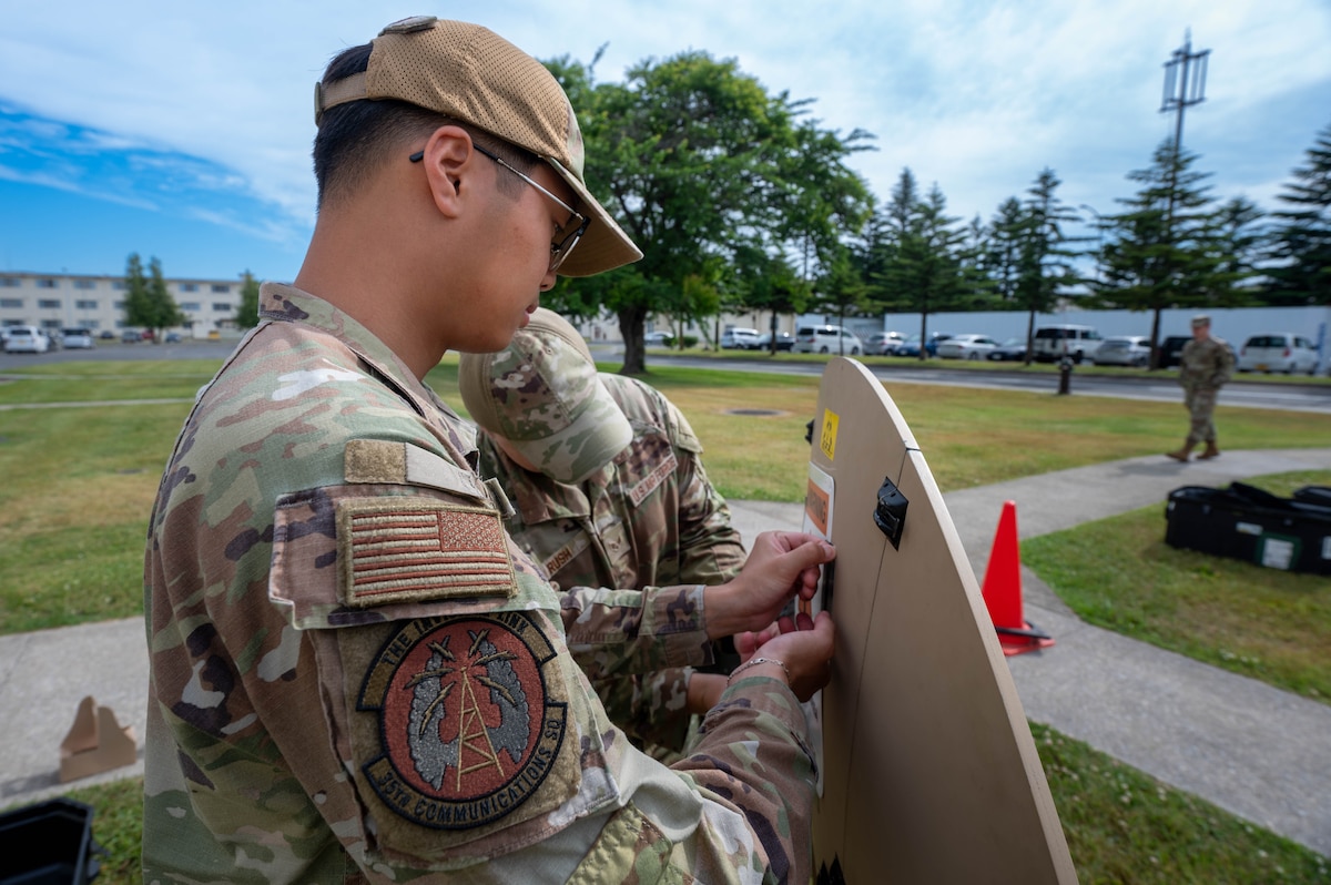 U.S. Air Force Airman 1st Class Akarawin Leelaura, 35th Communications Squadron radio frequency system transmission technician, secures a safety notice to a Hawkeye III Lite satellite system Rapid Response Communications Kit at Misawa Air Base, Japan, June 24, 2025.