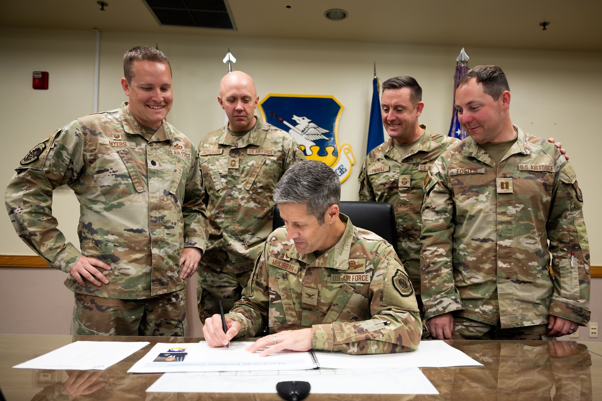 51st Fighter Wing senior leaders gather around U.S. Air Force Col. William McKibban, 51st Fighter Wing commander, as he signs the Osan 2035 Installation Development Plan