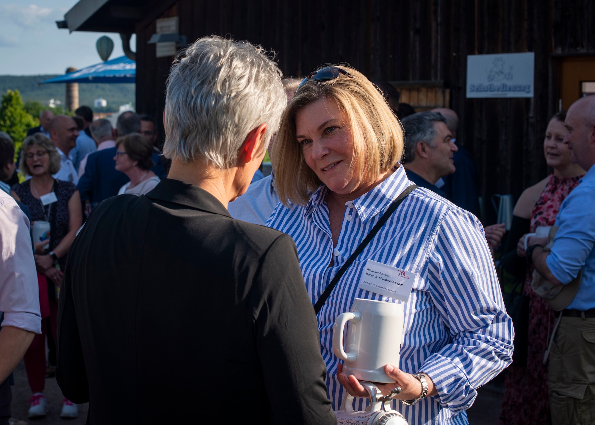 Mrs. Beate Kimmel, Lord Mayor of Kaiserslautern, coins U.S. Army Brig. Gen. Karen Monday-Gresham, 7th Mission Support Command deputy commanding general, during Kaiserslautern Summer Social, at the Gartenschau, Kaiserslautern, June 16, 2025. Monday-Gresham was responsible for executing mission command and regional support to all assigned, attached, or supported U.S. Army Reserve forces for the Commander, U.S. Army Europe and providing trained, ready units for mobilization and worldwide deployments. (U.S. Air Force photo by Senior Airman Sabrina Fuller-Judd)