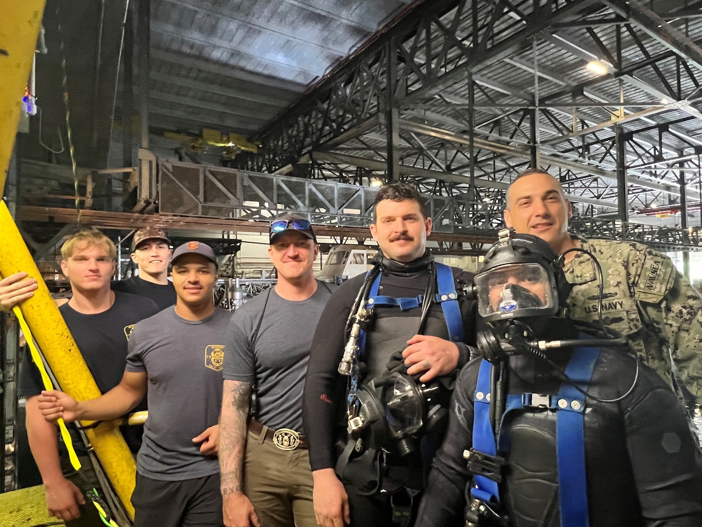 Naval Undersea Warfare Center (NUWC) Keyport Division’s Dive team poses for a photo with Naval Surface Warfare Center Carderock Division’s (NSWCCD)Commanding Officer at the David Taylor Model Basin at West Bethesda, Md. From May 27 to May 31, 2025, the six divers hand-removed 10-tons of corroded steel from the test basin floor in preparation for the 18th International Submarine Races, hosted by Carderock.