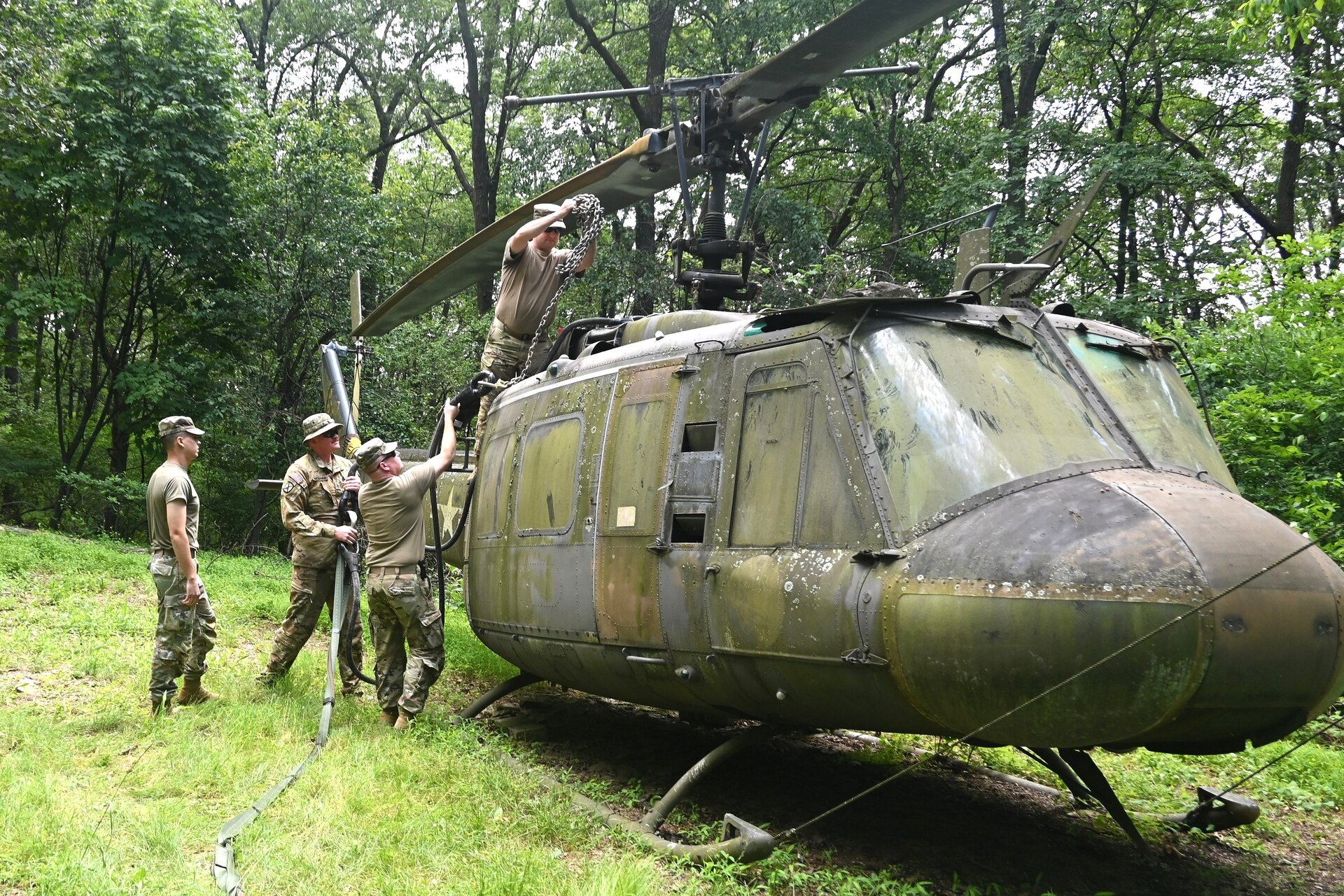 Soldiers from the 2-104th General Support Aviation Battalion, 28th Expeditionary Combat Aviation Brigade prepare a decommissioned UH-1 “Huey” helicopter to be air-lifted from the top of a mountain near Fort Indiantown Gap, Pennsylvania, to the installation June 20, 2025. (Pennsylvania National Guard photo by Brad Rhen)