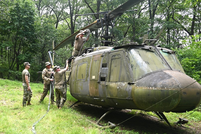 Soldiers from the 2-104th General Support Aviation Battalion, 28th Expeditionary Combat Aviation Brigade prepare a decommissioned UH-1 “Huey” helicopter to be air-lifted from the top of a mountain near Fort Indiantown Gap, Pennsylvania, to the installation June 20, 2025. (Pennsylvania National Guard photo by Brad Rhen)