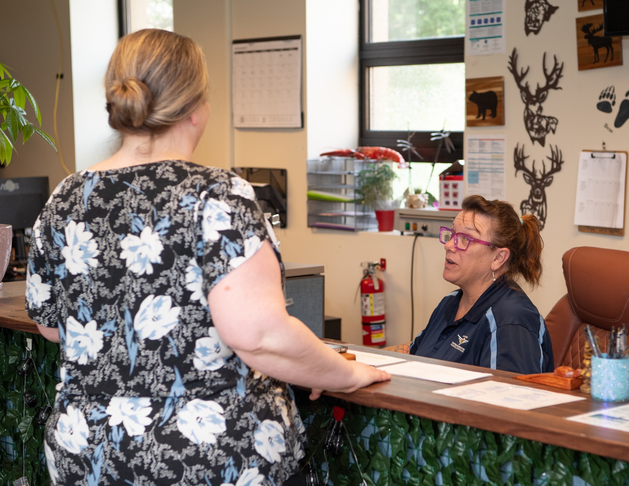 A patron stands near a counter while a customer service professional assists.