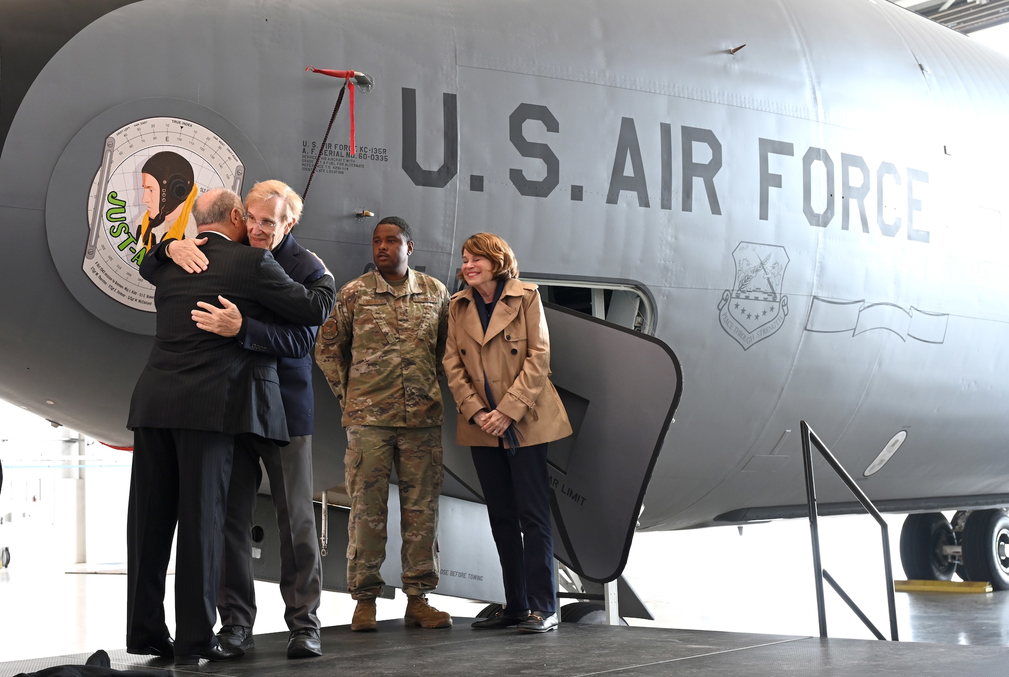 Steve Crosby, left, son of then-1st Lt. Harry Crosby, World War II and 100th Bomb Group navigator, and Jim Blakely, second left, hug after seeing the legacy nose art – “Just-A-Snappin” – honoring both of their fathers and the rest of the aircrew who flew on the B-17 Flying Fortress of the same name, as part of the Bremen mission during World War II, during the nose art unveiling ceremony at RAF Mildenhall, England, June 9, 2025. Just-A-Snappin is the latest addition to the 100th Air Refueling Wing nose art collection on the fleet of KC-135 Stratotankers, which honors the Bloody Hundredth legacy. (U.S. Air Force photo by Karen Abeyasekere)