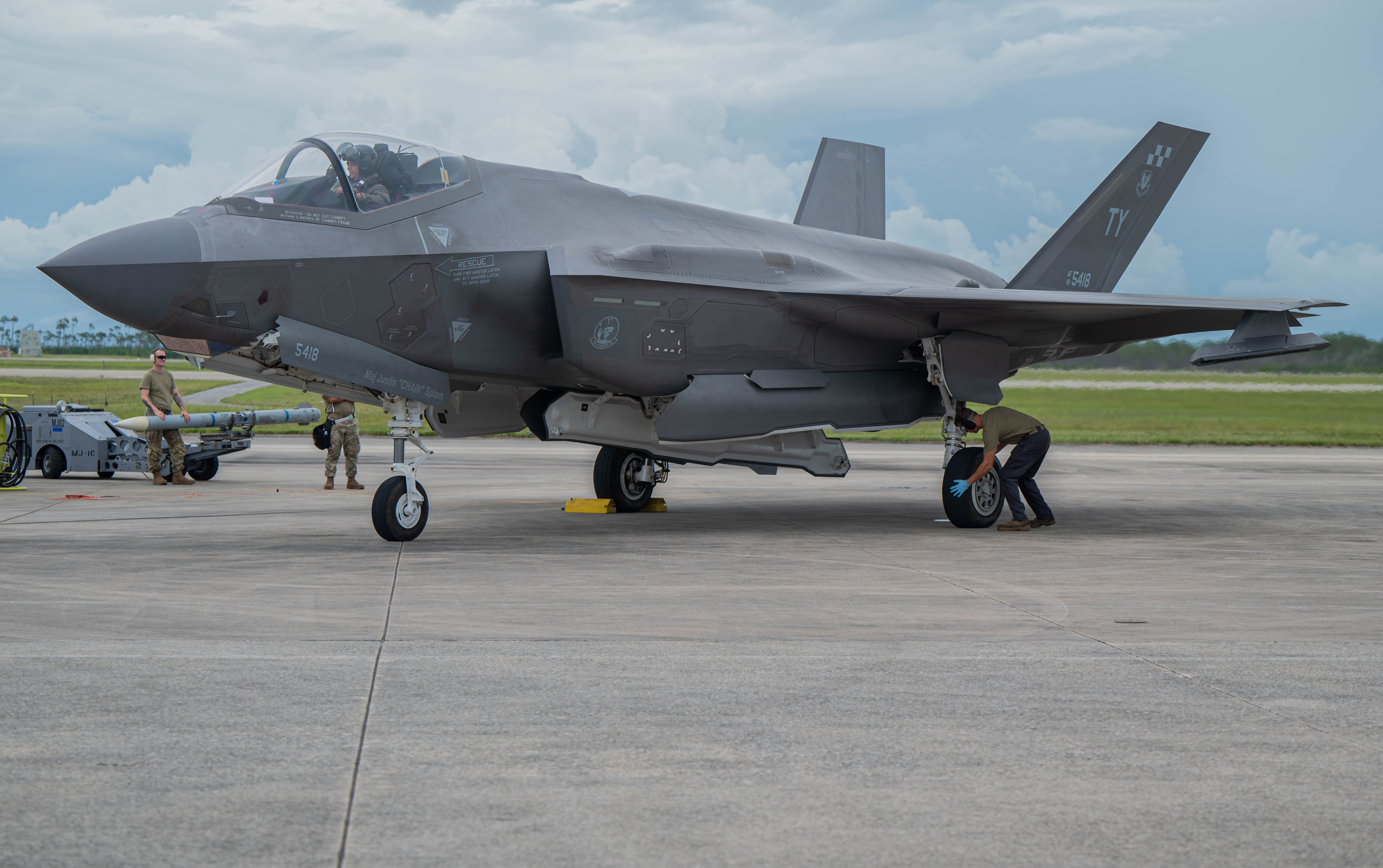 An F-35 is being checked over by Airman during a hot ICT
