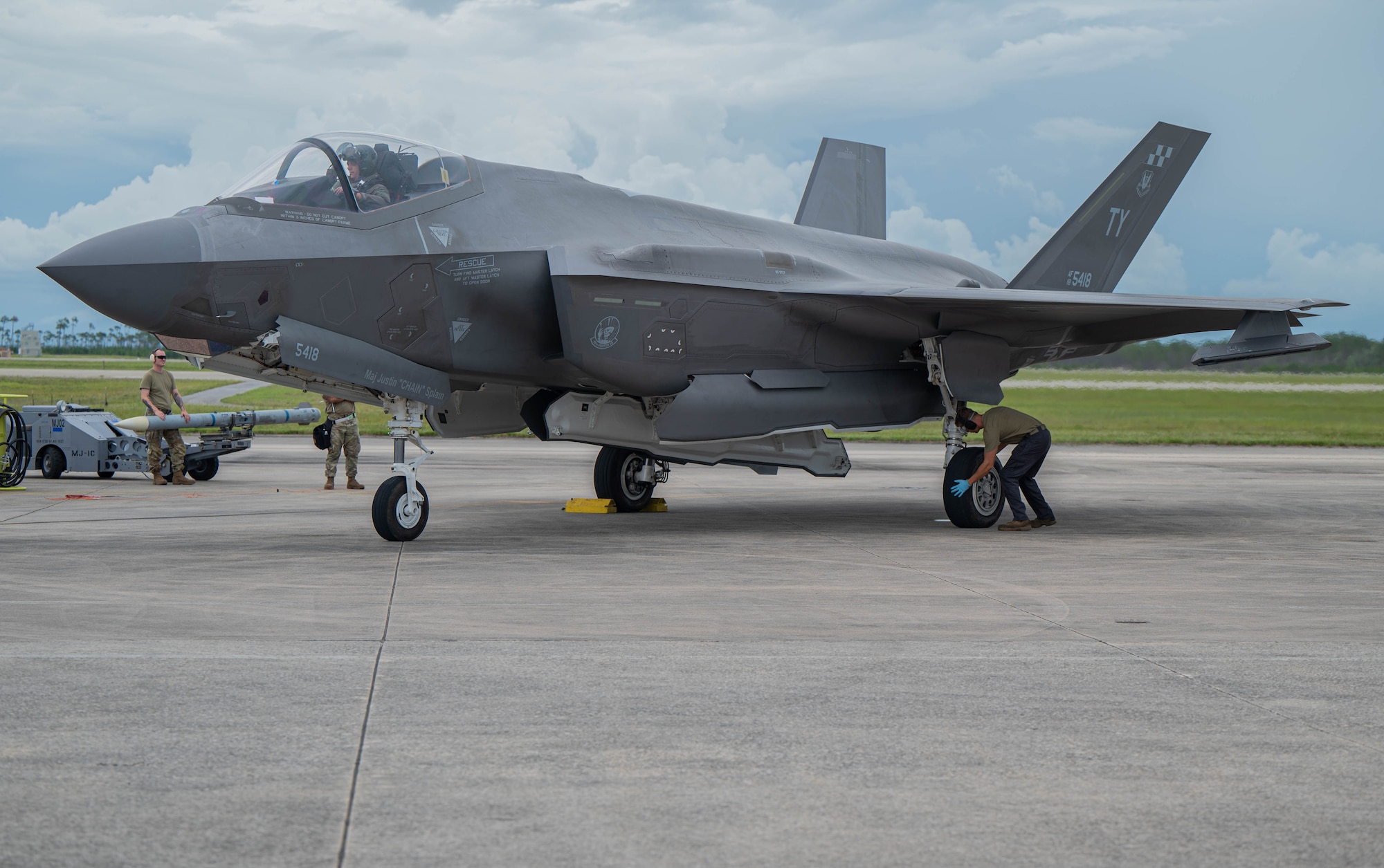 An F-35 is being checked over by Airman during a hot ICT