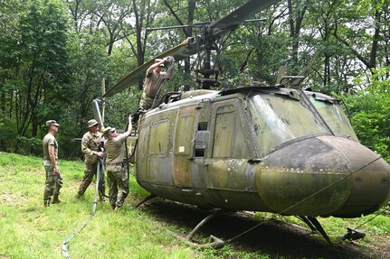 Soldiers from the 2-104th General Support Aviation Battalion, 28th Expeditionary Combat Aviation Brigade prepare a decommissioned UH-1 “Huey” helicopter to be air-lifted from the top of a mountain near Fort Indiantown Gap, Pennsylvania, to the installation June 20, 2025. (Pennsylvania National Guard photo by Brad Rhen)