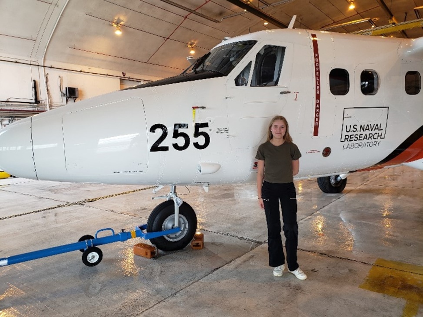 Miina Anvelt stands in front of the NRL Twin Otter aircraft assigned to the VXS-1 squadron at Naval Air Station Patuxent River during her SEAP internship on July, 19 2022.