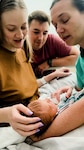 Winn Army Community Hospital midwife Capt. Erin Fallis holds Nathan Hardy during a check-in as mom KaRena and dad Justin look on. The Hardys choose to have their child at Winn after their original plan to give birth at a birthing center fell through. Their experience at Winn gave them the birth they hoped for.
