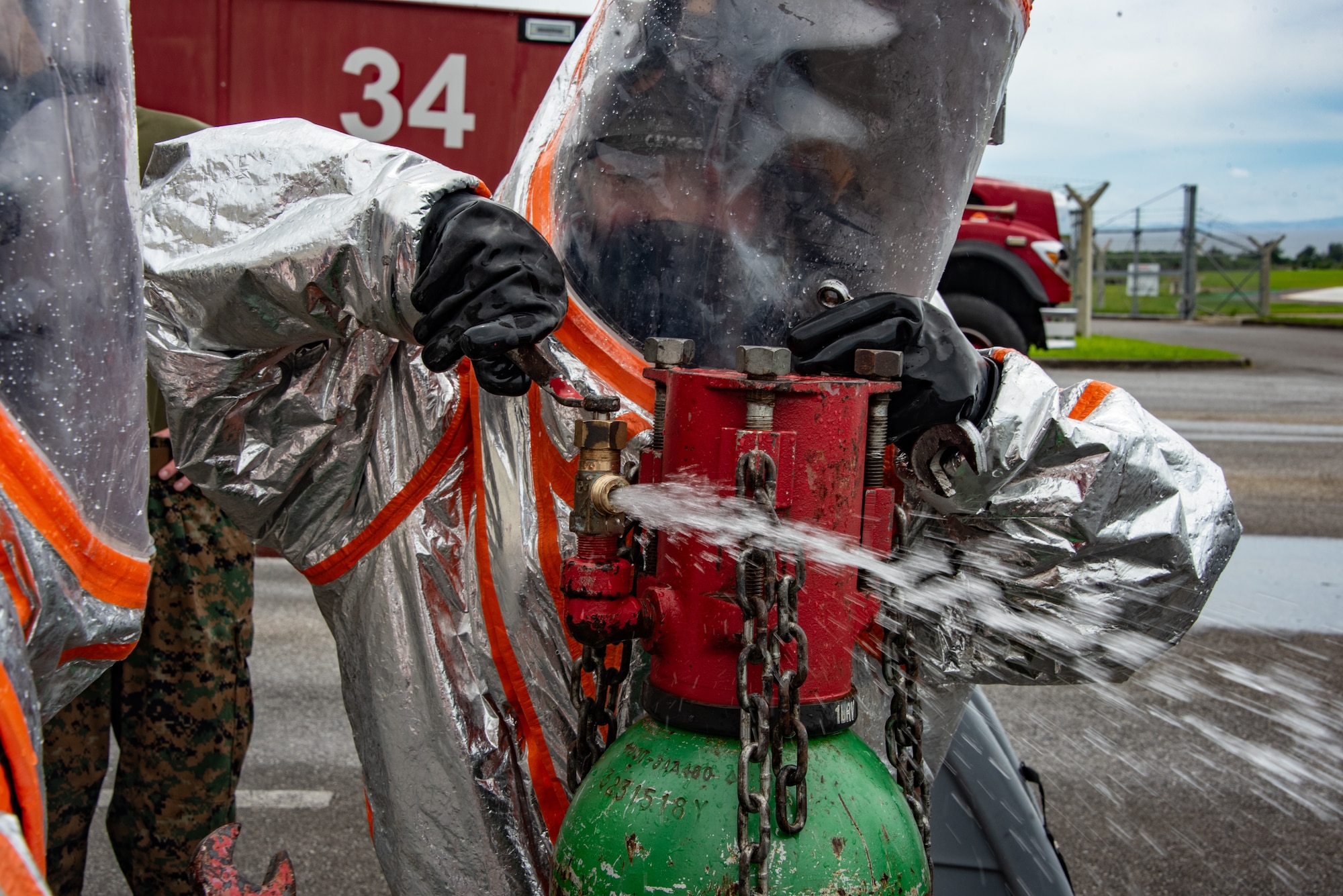 U.S. Air Force Airmen, Air National Guardsmen and U.S. Marines test a chlorine cylinder emergency kit component during a joint hazardous materials certification course at Kadena Air Base, Japan, June 18, 2025. The hands-on training builds familiarity with industrial safety tools used in chemical hazard response. (U.S. Air National Guard photo by Staff Sgt. Jesse Hanson)