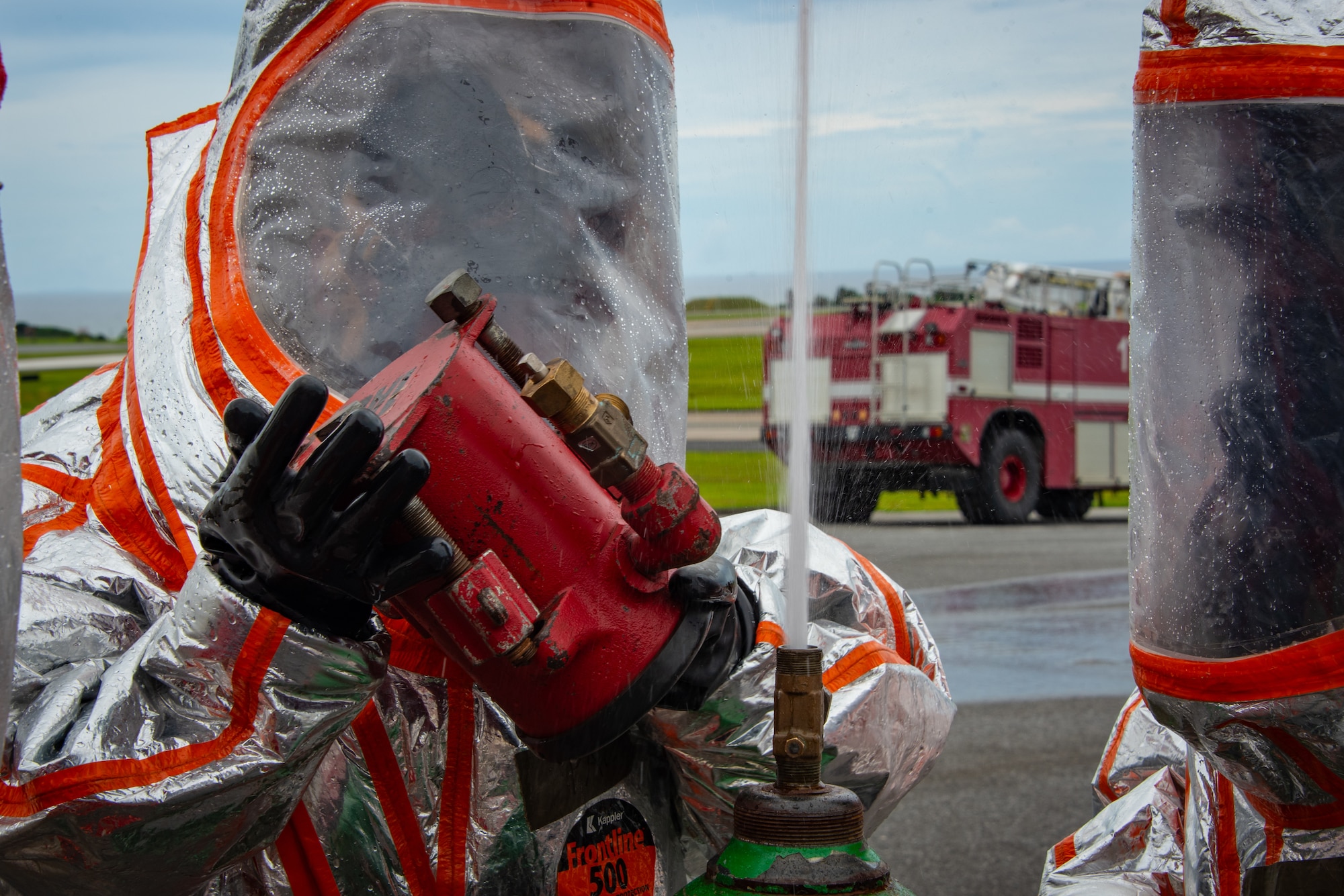 U.S. Air Force Airmen, Air National Guardsmen and U.S.Marines investigate a simulated chlorine leak and prepare to install an emergency kit during a joint hazardous materials recertification course at Kadena Air Base, Japan, June 18, 2025. Proper placement of kit components is critical for safely containing hazardous leaks in pressurized systems. (U.S. Air National Guard photo by Staff Sgt. Jesse Hanson)