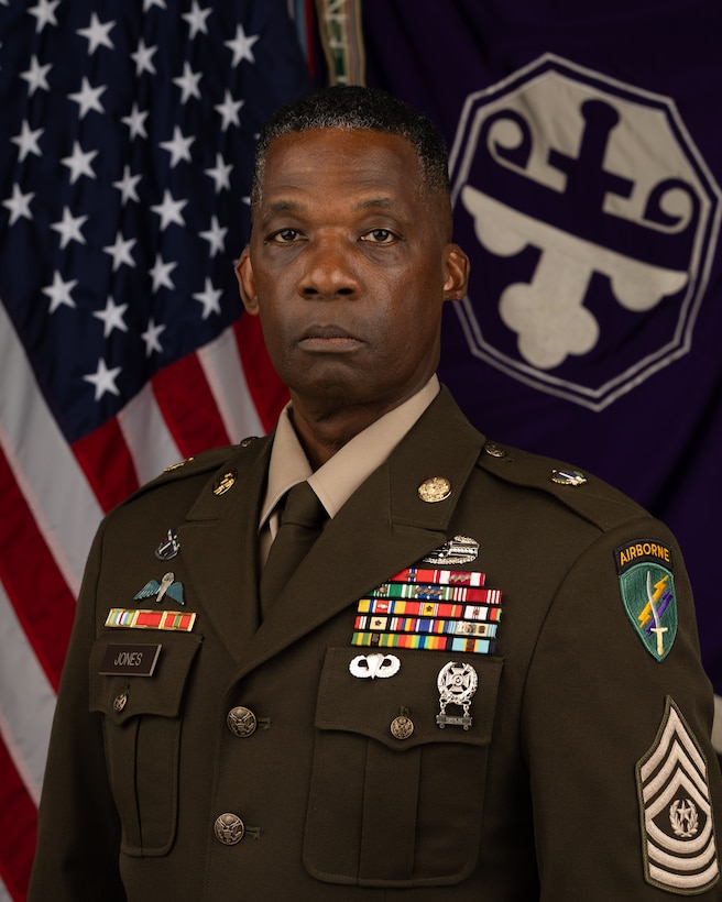 CSM Carlton Jones poses for his command photo in front of the flag of the United States of America and the flag of the 352nd Civil Affairs Command