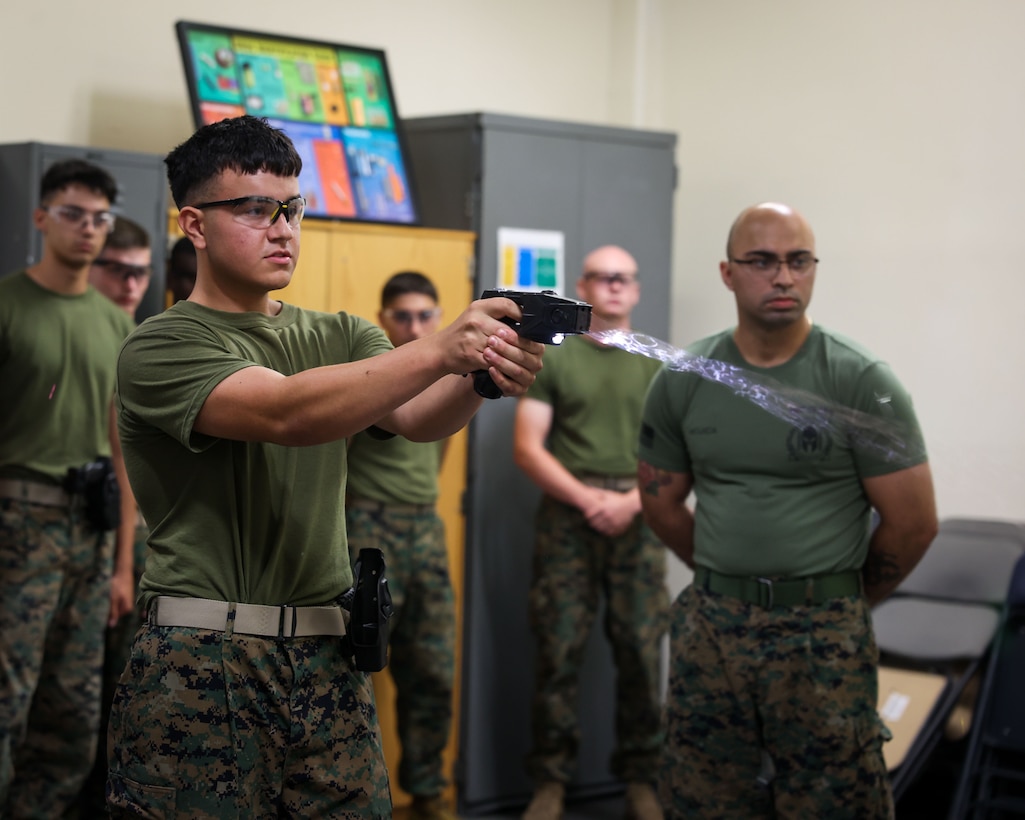U.S. Marine Corps Lance Cpl. Anthony Verastegui, a student at Guard Academy, Guard Company, Marine Barracks Washington, conducts taser qualification in Washington, D.C., June 19, 2025. The training certifies Marines in the proper use and effects of non-lethal force as part of their law enforcement responsibilities. (U.S. Marine Corps photo by Lance Cpl. Brynn L. Bouchard)