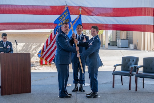 U.S. Air Force Col. Chuck W. Redmond, 563rd Rescue Group commander, left, receives the squadron guidon from Lt. Col. Jeffry S. Edson, outgoing 58th Rescue Squadron (RQS) commander, during the 58th RQS Inactivation Ceremony at Nellis Air Force Base, Nevada, June 17, 2025.