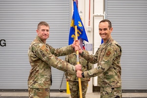 Two airmen holding onto a guidon