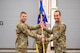 Two airmen holding onto a guidon