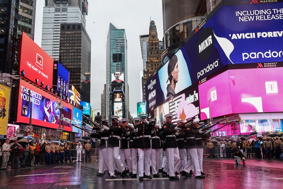 U.S. Marines with the United States Marine Corps Silent Drill Platoon execute their "bursting bomb" sequence during their performance in Times Square, New York City, N.Y., May 21, 2025. The Silent Drill Platoon helped kick off Fleet Week New York with a performance in Times Square. Fleet Week New York is an annual celebration where U.S. Navy, Marine Corps, and Coast Guard ships dock in New York City, allowing the public to tour vessels and meet service members. By participating in ceremonies like this, Marine Barracks Washington connects the traditions of the Marine Corps with the American people they serve. (U.S. Marine Corps photo by Lance Cpl. Christopher Prelle)