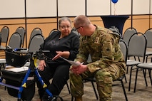 Military members and civilians interact during an honorary commander induction ceremony.