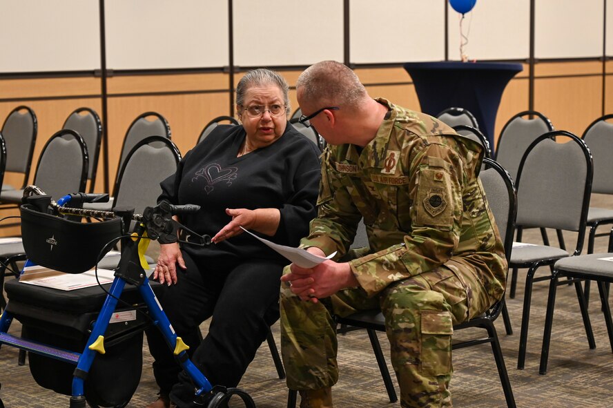 Military members and civilians interact during an honorary commander induction ceremony.