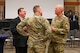 Military members and civilians interact during an honorary commander induction ceremony.
