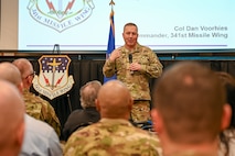 Military members and civilians interact during an honorary commander induction ceremony.