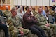 Military members and civilians interact during an honorary commander induction ceremony.