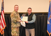 Military members and civilians interact during an honorary commander induction ceremony.