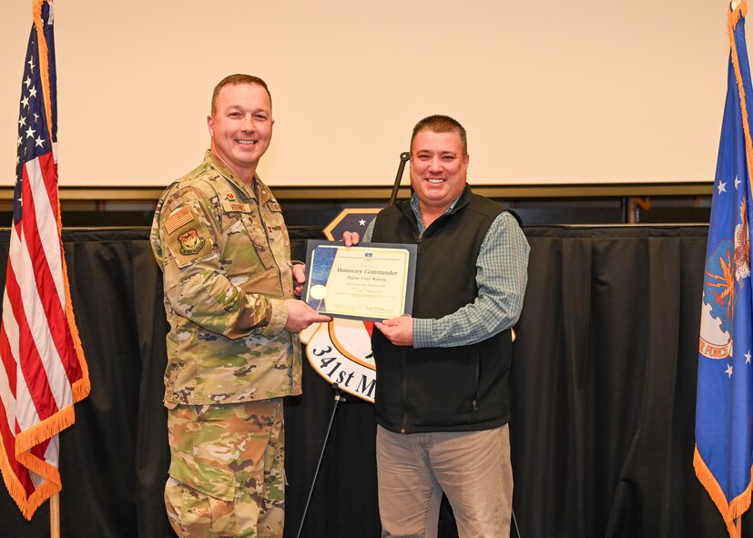 Military members and civilians interact during an honorary commander induction ceremony.