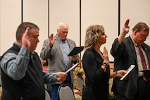 Military members and civilians interact during an honorary commander induction ceremony.