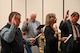 Military members and civilians interact during an honorary commander induction ceremony.