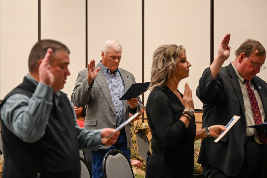 Military members and civilians interact during an honorary commander induction ceremony.