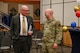 Military members and civilians interact during an honorary commander induction ceremony.