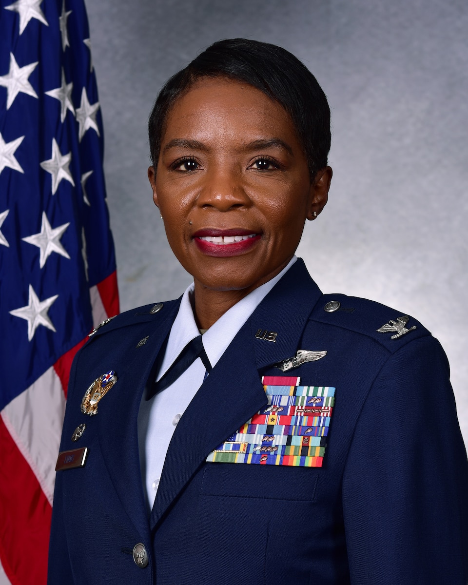 Woman poses for official photo in front of American flag.