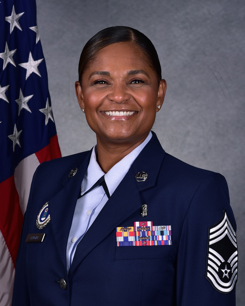 Woman poses for official photo in front of American flag.
