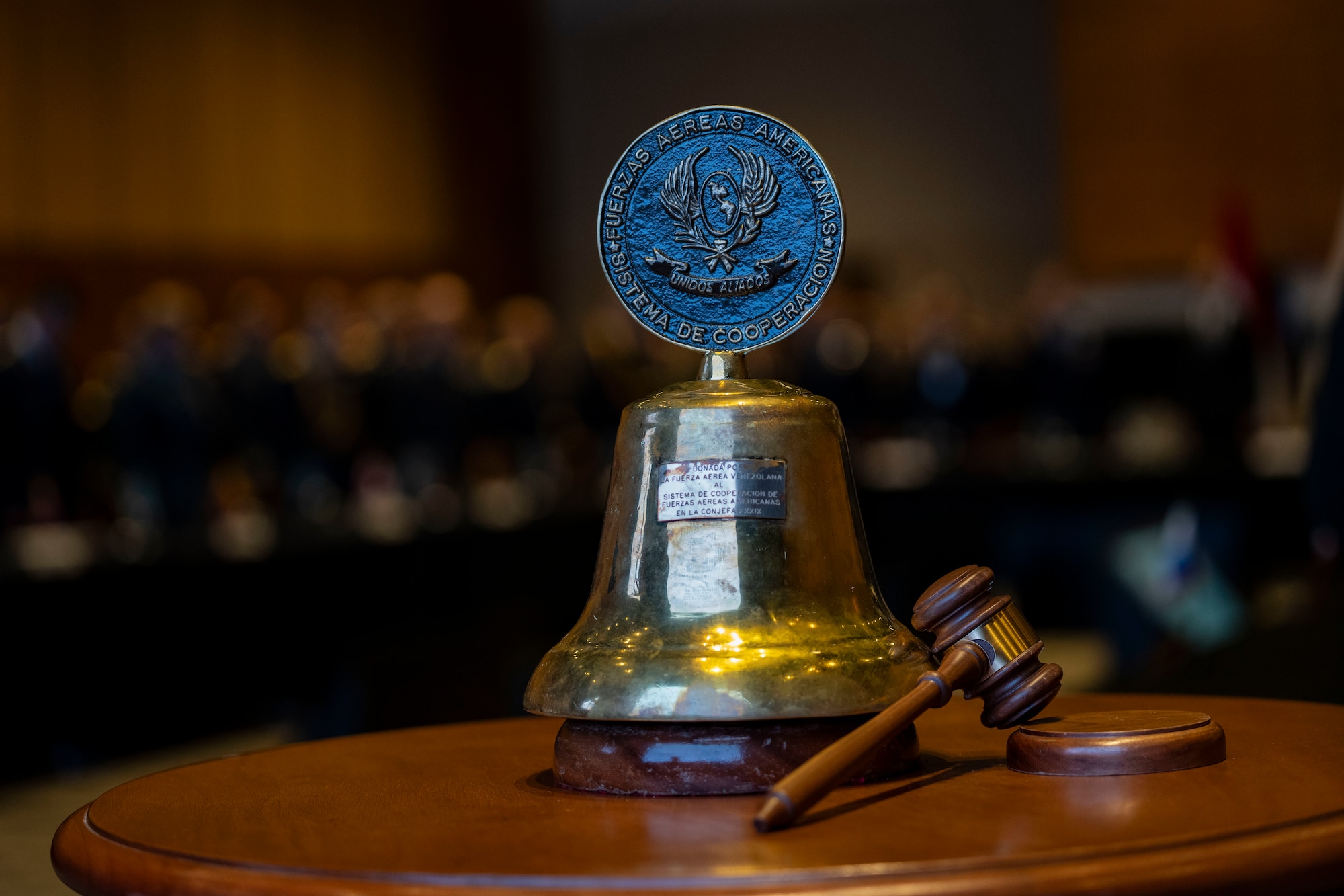 System of Cooperation Among the American Air Forces (SICOFAA) ceremonial bell sits on the table during the 65th Conference of the American Air Chiefs (CONJEFAMER) meeting in Asuncion, Paraguay, June 18, 2025. SICOFAA began as a meeting of officers from 13 different countries in 1961 with the goal of strengthening the bond between the Air Forces in the Western Hemisphere. It has since grown to include XX countries. The passing of the bell stands as a long-standing tradition in SICOFAA’s CONJEFAMER and embodies the unity and shared mission among Western Hemisphere air forces. (U.S. Air Force photo by Andrea Jenkins)