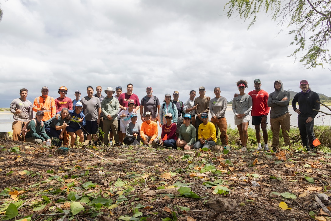 Marine Corps Base Hawaii (MCBH) personnel and Ola Nu’upia Hui members pose for a photo during a community and environmental stewardship workday coordinated by the Environmental Compliance and Protection Division at the Nu’upia Ponds Wildlife Management Area, MCBH, June 14, 2025. The event was held to restabilize the ecological and cultural integrity of the fishpond as part of the ongoing efforts to preserve traditional Hawaiian aquaculture systems and enhance environmental resilience and strengthen partnerships between the military and the local community through shared stewardship. (U.S. Marine Corps photo by Sgt. Julian Elliott-Drouin)