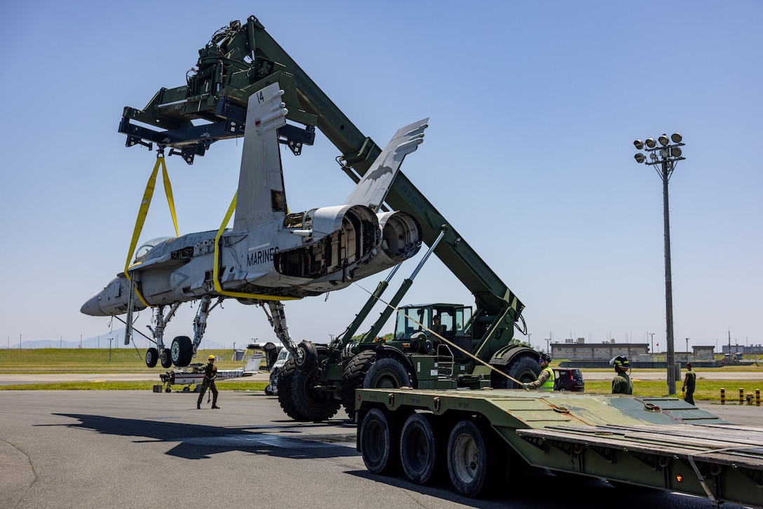 A Royal Airman from the Joint Aircraft Recovery Transportation Squadron, Royal Air Force, and a German Airman German Air Force Command 4 II, help guide an F/A-18C Hornet aircraft to the ground during Crash Damaged or Disabled Aircraft Recovery training at Marine Corps Air Station Iwakuni, Japan, June 5, 2025. CDDAR training was held for the first time at MCAS Iwakuni by the F-35 Joint Program Office to bring multiple nations together to enhance aircraft recovery and rescue techniques and capabilities across North Atlantic Treaty Organization Allies. (U.S. Marine Corps photo by Cpl. Dahkareo Pritchett)