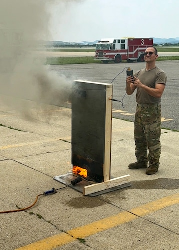 U.S. Air Force Staff Sgt. Adam Carroll, 51st Civil Engineer Squadron firefighter, measures the temperature of a fire behavior demonstrator during Osan’s first bilingual InSource Consulting Fire Training at Osan Air Base, Republic of Korea, June 18, 2025. The course was conducted in both English and Korean, with a live translator to help ensure key concepts were clearly communicated. (U.S. Air Force photo by Staff Sgt. Sarah Williams)