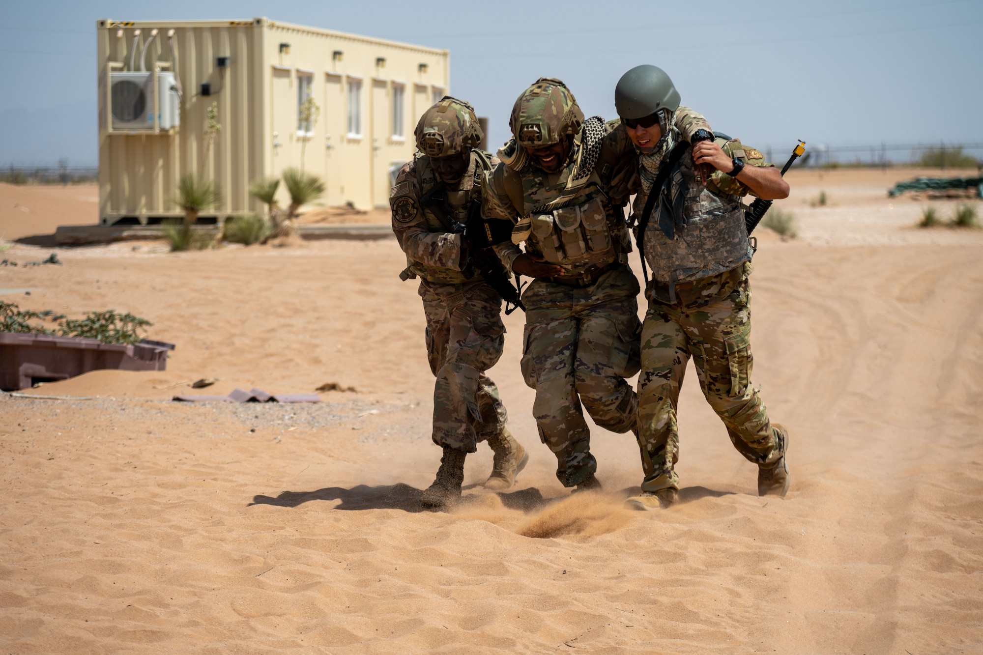 Airmen assigned to the 23d Air Task Force carry a wounded teammate to safety as they defend a forward operating base from a simulated enemy attack during an expeditionary skills exercise at Fort Bliss, Texas, June 16, 2025.