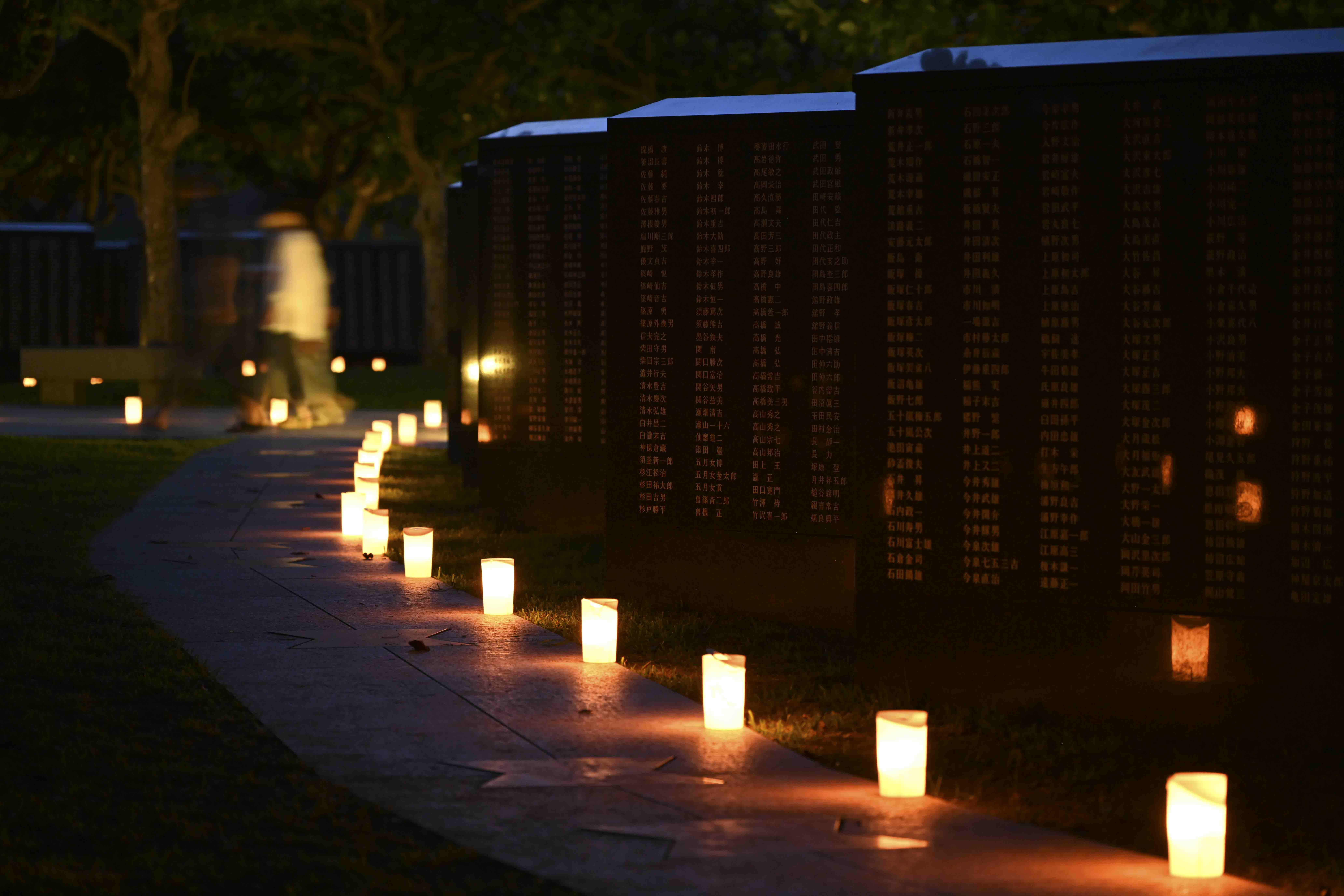 Candles lit by local volunteers and U.S. Navy Sailors stationed on Okinawa illuminate memorial walls following a volunteer candle lighting event at Peace Memorial Park in Itoman, Okinawa, Japan, June 22, 2025.