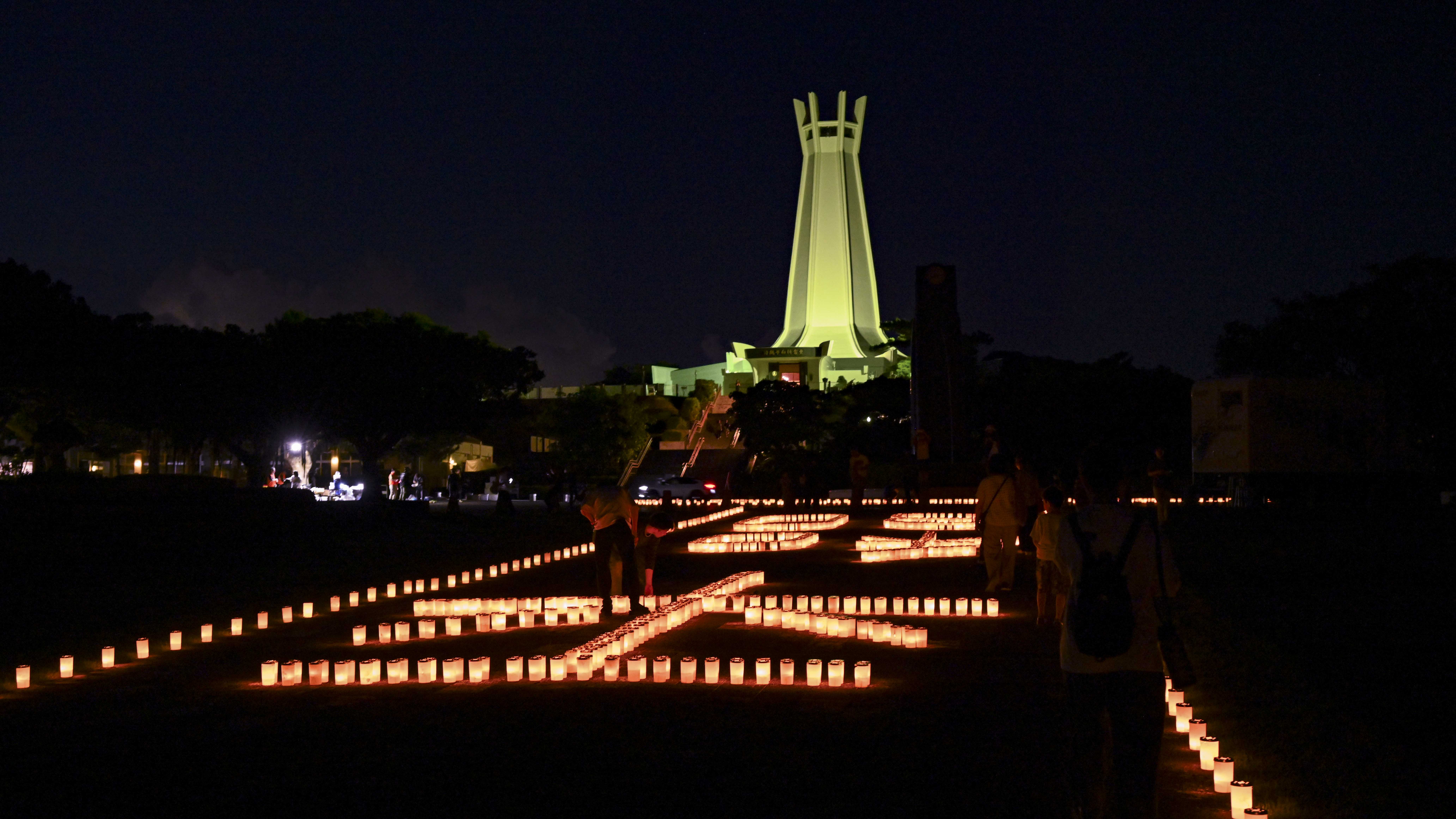 Candles lit by local volunteers and U.S. Navy Sailors stationed on Okinawa spell out the Japanese symbols for “peace” during a volunteer candle lighting event at Peace Memorial Park in Itoman, Okinawa, Japan, June 22, 2025.