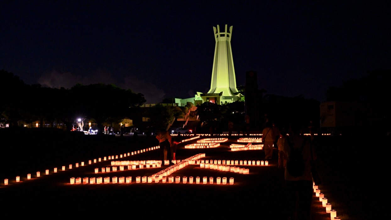 Candles lit by local volunteers and U.S. Navy Sailors stationed on Okinawa spell out the Japanese symbols for “peace” during a volunteer candle lighting event at Peace Memorial Park in Itoman, Okinawa, Japan, June 22, 2025.