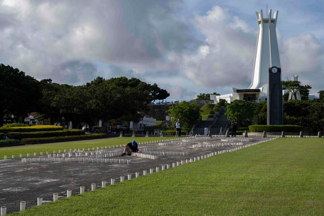 Hospital Corpsman 2nd Class Andrea Mayrose, from Salem, South Dakota, assigned to U.S. Naval Hospital Okinawa, helps light the more than 7,000 candles that illuminate the memorials walls and walk ways at Peace Memorial Park during a volunteer candle lighting event in Itoman, Okinawa, Japan, June 22, 2025.