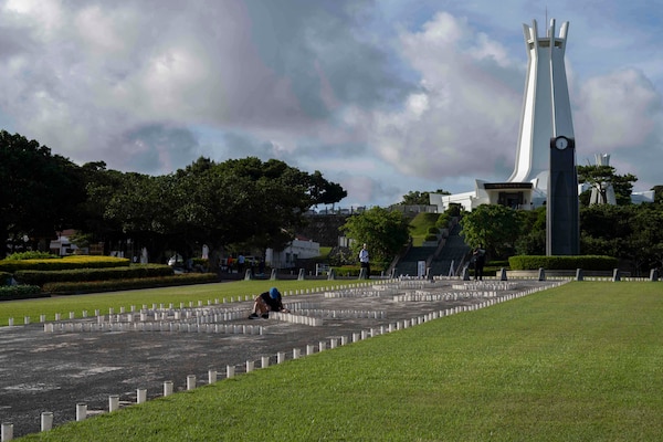 Hospital Corpsman 2nd Class Andrea Mayrose, from Salem, South Dakota, assigned to U.S. Naval Hospital Okinawa, helps light the more than 7,000 candles that illuminate the memorials walls and walk ways at Peace Memorial Park during a volunteer candle lighting event in Itoman, Okinawa, Japan, June 22, 2025.