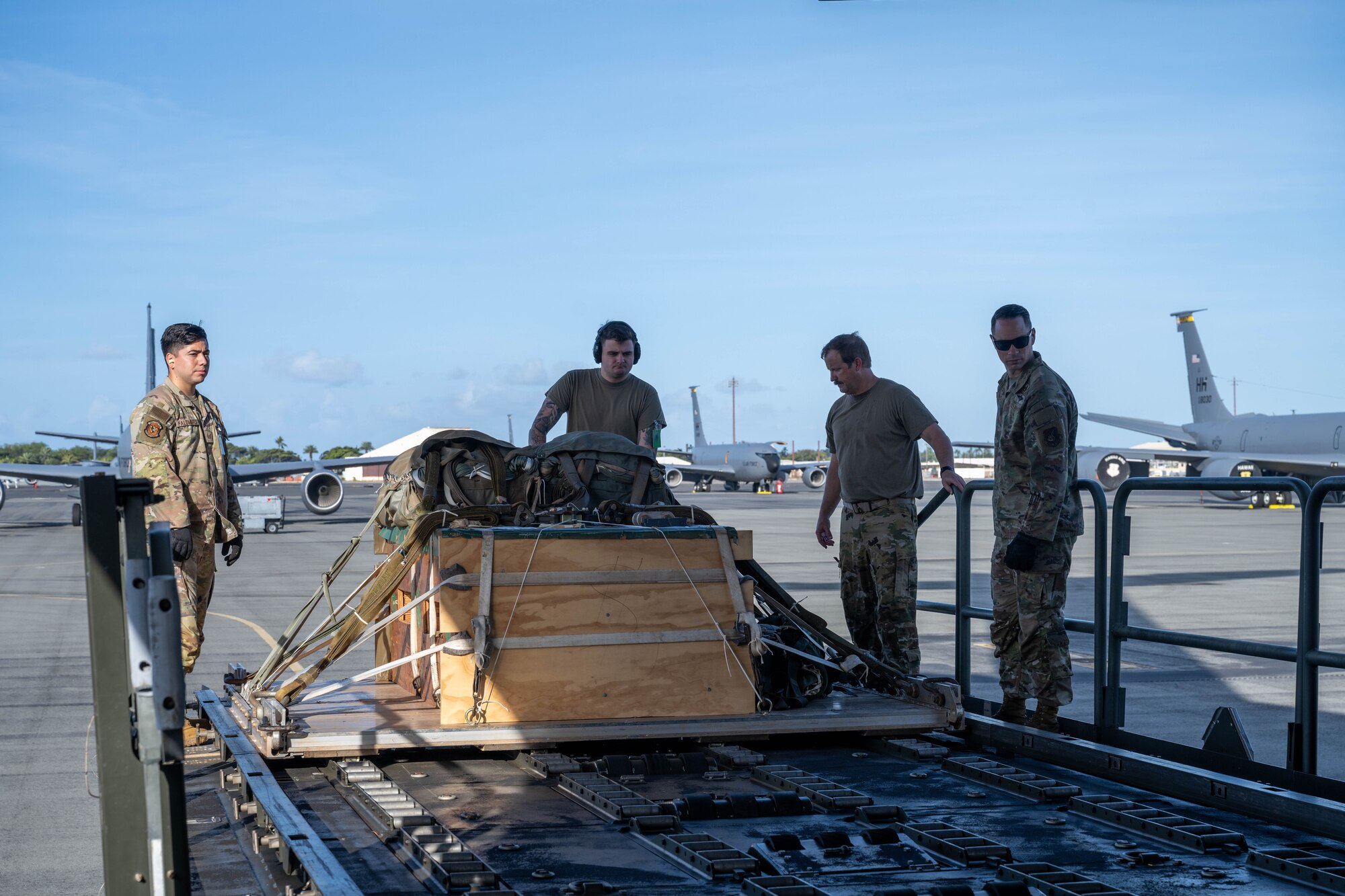 U.S. Air Force Airmen load cargo from a K-loader to a C-17 Globemaster III on the flightline of Joint Base Pearl Harbor-Hickam, Hawaii.