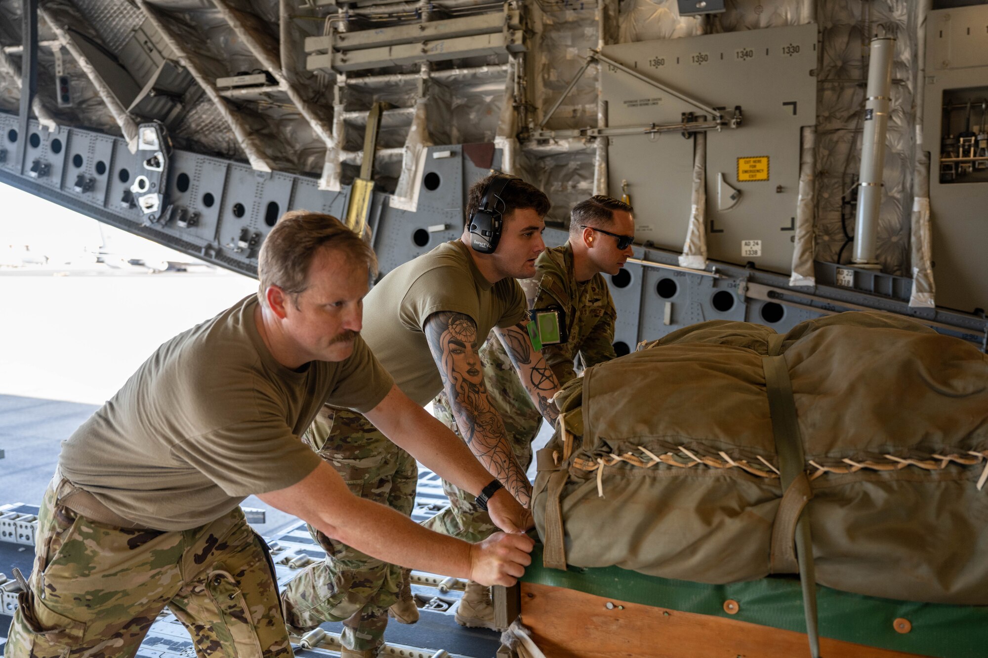 U.S. Air Force Airmen load cargo on to a C-17 Globemaster III on the flightline of Joint Base Pearl Harbor-Hickam, Hawaii.