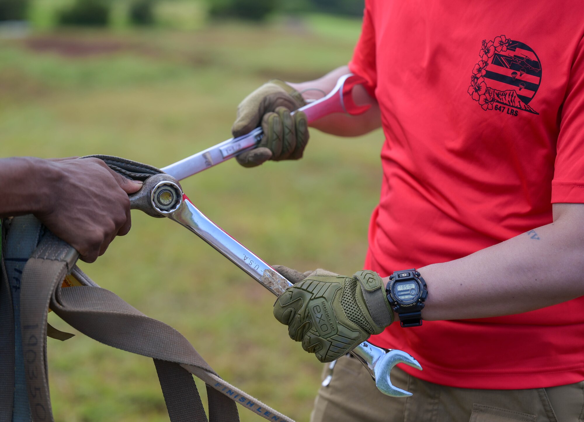 A U.S. Air Force Airmen uses a tool to cut a rope.
