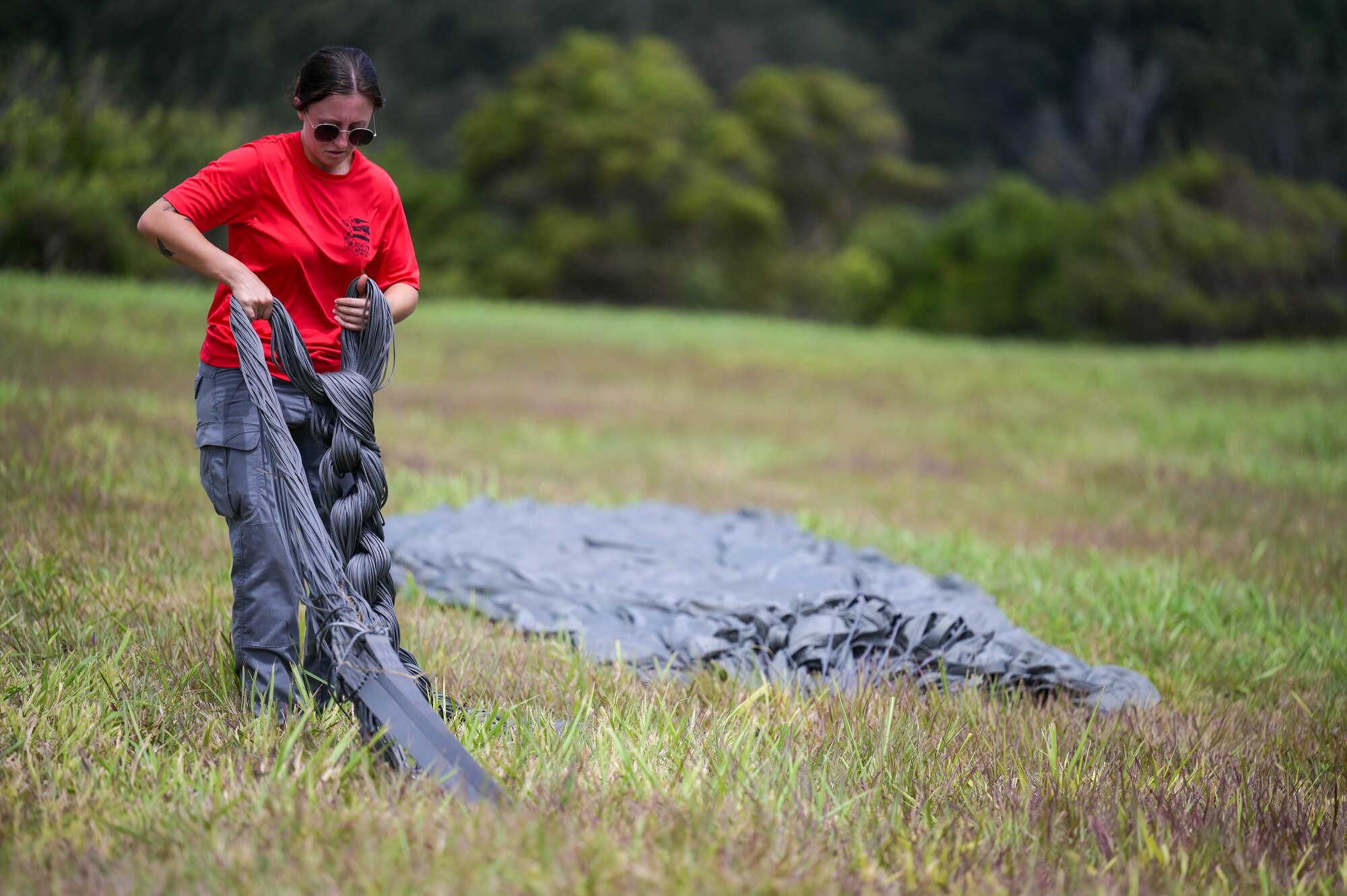 A U.S. Air Force Airmen folds up a used parachute after receiving an airdrop from a C-17.